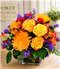 Citrus Sunshine flower bouquet with yellow roses, orange alstroemeria, spider mums, red carnations and purple statice in a glass cube.
