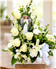 Heavenly Light white sympathy flower arrangement with roses, lilies, snapdragons, alstroemeria, greenery, and an angel keepsake