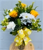 Bouquet with white daisies, yellow roses, carnations, and greenery finished with a yellow daisy-print bow.