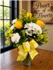 Bouquet with white daisies, yellow roses, carnations, and greenery finished with a yellow daisy-print bow.