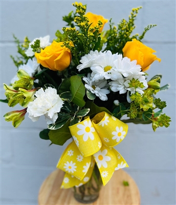 Bouquet with white daisies, yellow roses, carnations, and greenery finished with a yellow daisy-print bow.