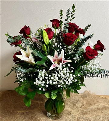 Romantic bouquet with red roses and stargazer lilies in a glass vase arrangement