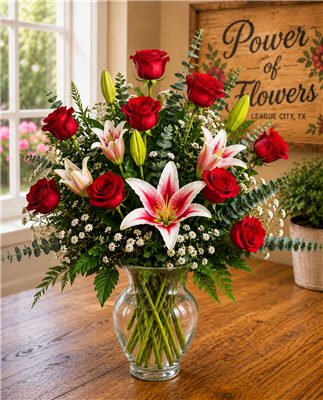 Red rose and stargazer lily arrangement with baby's breath and eucalyptus in a glass vase