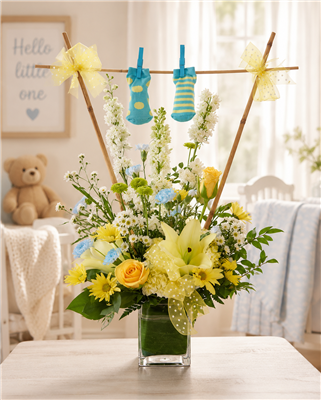 New baby boy bouquet with yellow roses, lilies, white larkspur, carnations, yellow daisies, and baby booties.