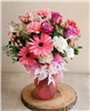 Pink and white mixed bouquet with roses, gerbera daisies, carnations, alstroemeria, and greenery in a frosted vase.