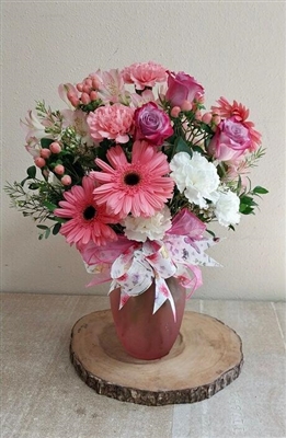 Pink and white mixed bouquet with roses, gerbera daisies, carnations, alstroemeria, and greenery in a frosted vase.
