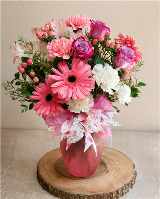 Pink and white mixed bouquet with roses, gerbera daisies, carnations, alstroemeria, and greenery in a frosted vase.
