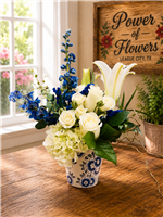 Blue and white bouquet with roses hydrangea lilies and delphinium in a ceramic Delft style vase