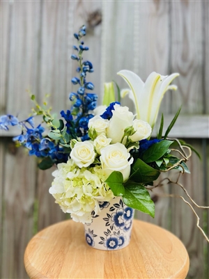 Blue and white bouquet with roses hydrangea lilies and delphinium in a ceramic Delft style vase