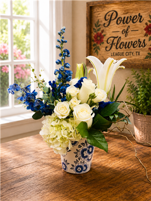 Blue and white bouquet with roses hydrangea lilies and delphinium in a ceramic Delft style vase