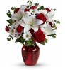 Red and white floral arrangement with roses, Asiatic lilies, mini carnations, and chrysanthemums in a ruby glass vase