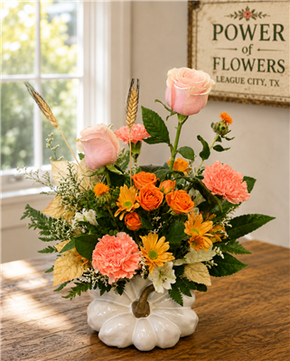 Blush roses, peach carnations, orange spray roses, yellow daisy mums, and limonium arranged in a hand-painted white pumpkin vase with gold stem.