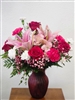 Star Gazer floral arrangement with stargazer lilies, pink carnations, roses, white mini carnations, and pink alstroemeria in a swirl keepsake vase