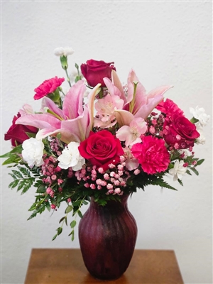 Star Gazer floral arrangement with stargazer lilies, pink carnations, roses, white mini carnations, and pink alstroemeria in a swirl keepsake vase