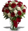Premium bouquet of red and white roses with Queen Anneâ€™s lace and greenery in a tall clear vase.