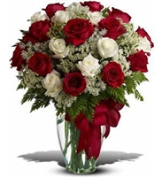 Premium bouquet of red and white roses with Queen Anneâ€™s lace and greenery in a tall clear vase.