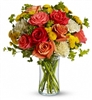 Citrus-Kissed Fall bouquet with orange roses, light yellow carnations, yellow button spray mums, and greens in a slender gathering vase