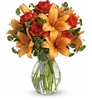 Firey Lily and Rose arrangement with orange Asiatic lilies and orange roses in a clear glass vase