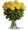 Yellow rose bouquet with solidago and greenery in a glass vase friendship arrangement