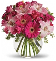 Pink floral arrangement with roses, Asiatic lilies, hot pink gerbera daisies, and carnations in a clear glass vase