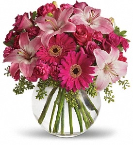 Pink floral arrangement with roses, Asiatic lilies, hot pink gerbera daisies, and carnations in a clear glass vase