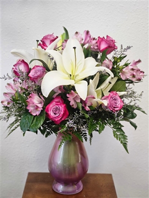 Tall pink and lavender bouquet with roses, lilies, and alstroemeria in a vase arrangement