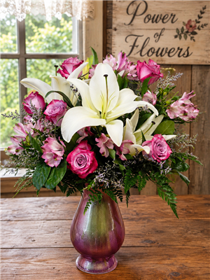 Tall pink and lavender bouquet with roses, lilies, and alstroemeria in a vase arrangement