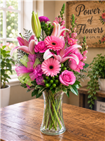 Pink roses and lilies bouquet with snapdragons, gerbera daisies, carnations, and greenery in a clear vase
Bright pink birthday flower arrangement with roses, lilies, and carnations, all-around design.