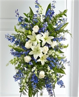 Blue and white standing sympathy tribute with lilies, roses, delphinium, and snapdragons