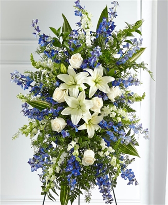 Blue and white standing sympathy tribute with lilies, roses, delphinium, and snapdragons