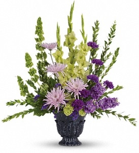 Lavender and green gladioli tribute bouquet with purple carnations in a timeless urn, one-sided design
Sympathy floral arrangement with green gladioli, lavender stock, and carnations for memorial service.