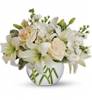 Isle of White arrangement with cream roses, white Asiatic lilies, and stock in a clear glass vase