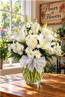Isle of White arrangement with cream roses, white Asiatic lilies, and stock in a clear glass vase
