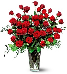 Three dozen long-stem red roses arranged in a tall clear glass vase with lush greenery.